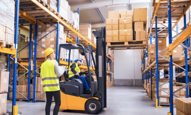 Trabajadores levantando cajas con maquinaria